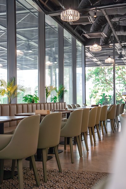 Inside Original Greens at Shaw Plaza: sage chairs, banquette and garden views