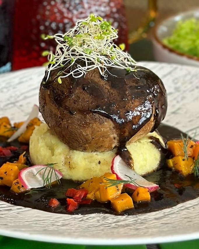 Stuffed portobello mushroom on mashed potato with pumpkin and radish